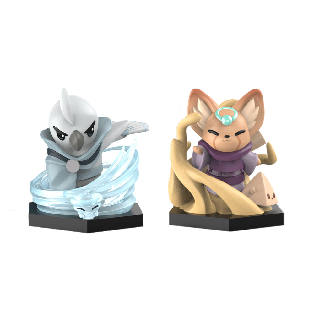 The "Command of Nature: Sand & Wind Expansion Vinyl Figure Set" by Unstable Games includes two small figurines on black bases. The left figurine features a bird-like creature surrounded by blue wind swirls, while the right one showcases a cat-like creature with a sand swirl and a turquoise gem on its forehead.